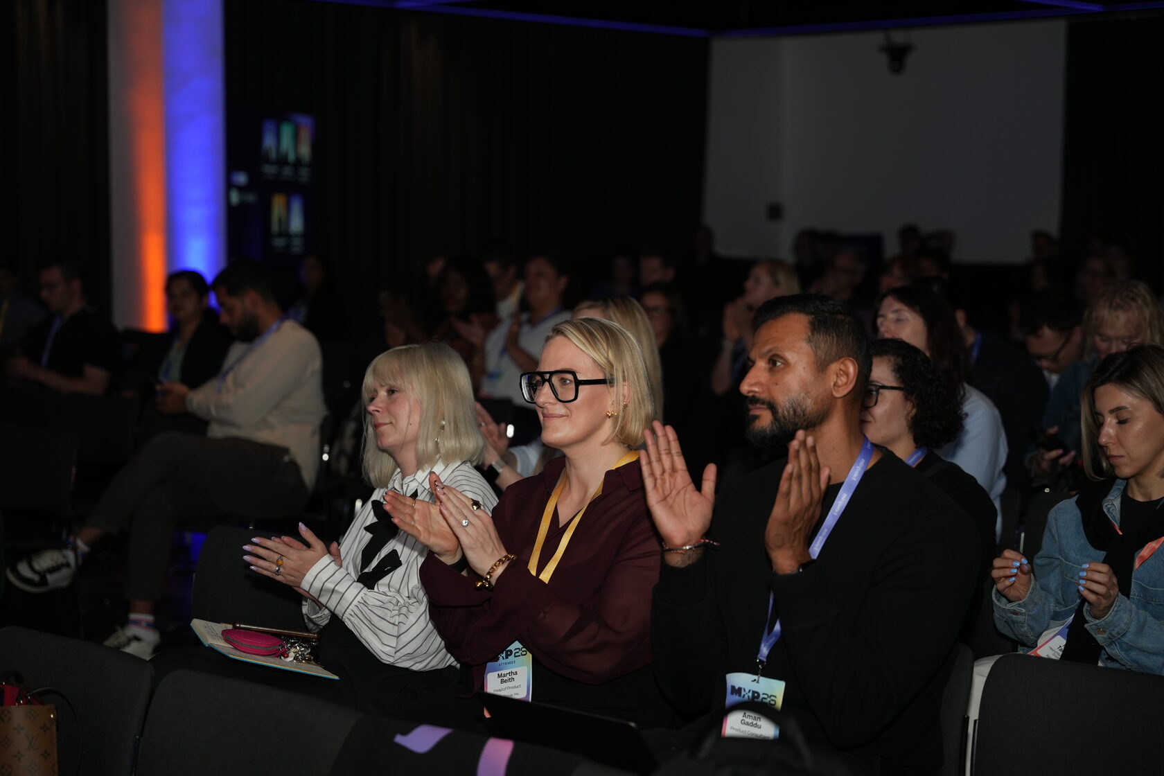 Audience members applauding during a conference