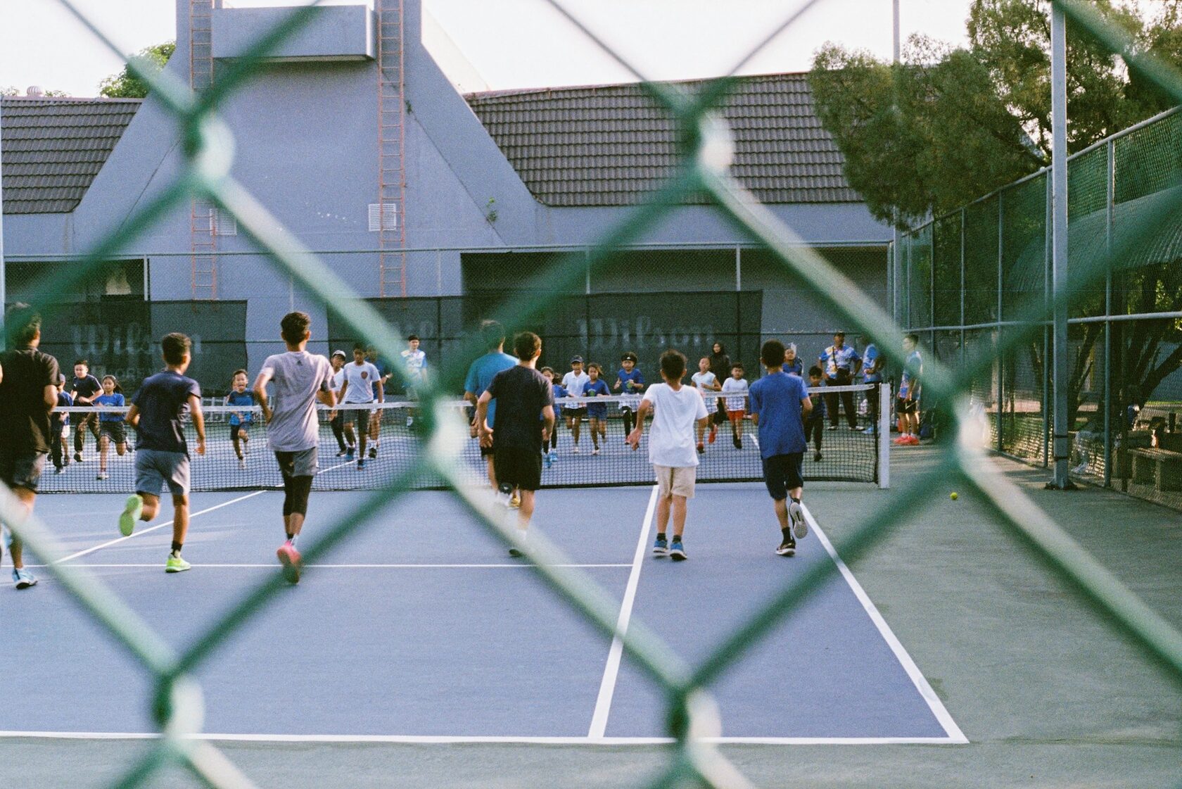 Kids smiling and laughing during a junior tennis lesson