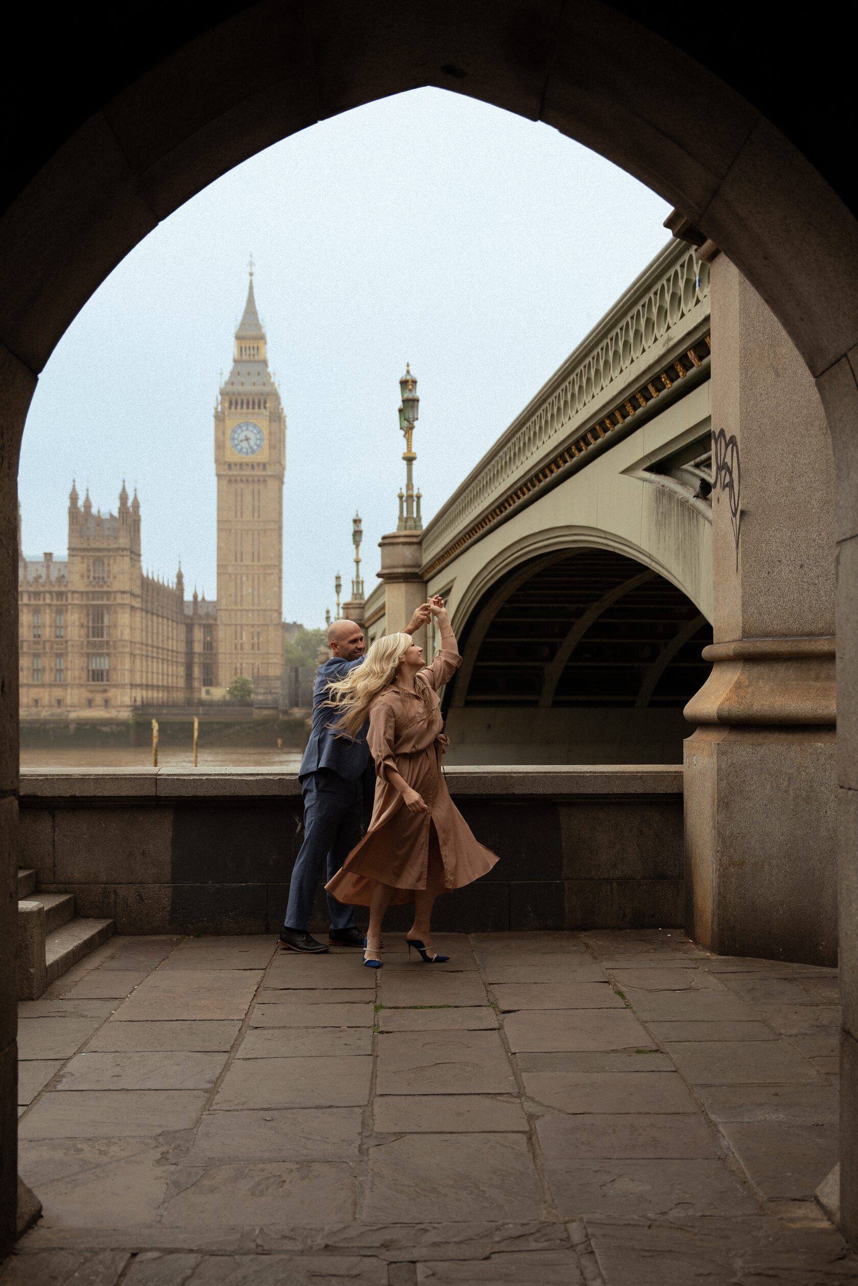A couple dancing under the Westminster Bridge arch