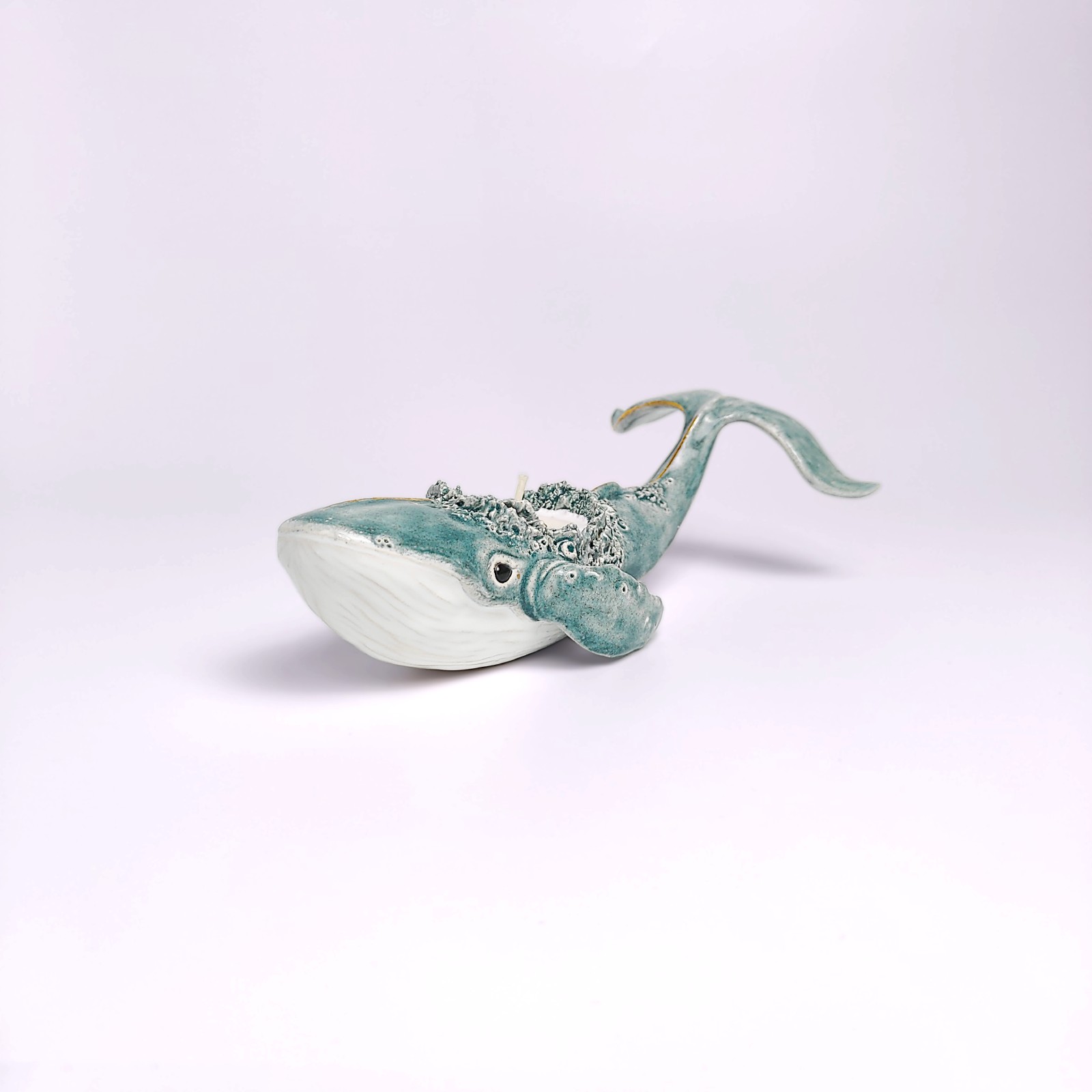 Unique handmade lagoon-colored ceramic whale with detailed sculptural texture and a built-in candle, inspired by ocean forms