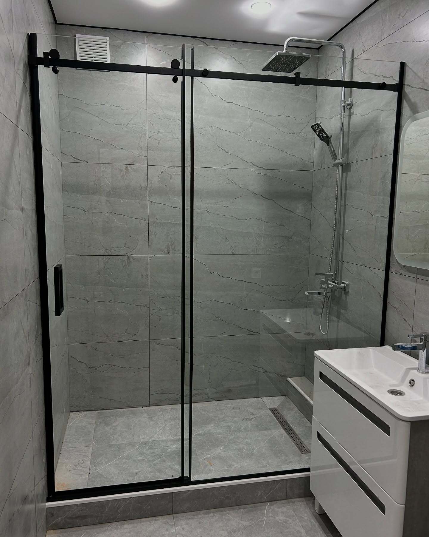 Sklenená zástena Walk-in v modernej kúpeľni s prirodzeným svetlom