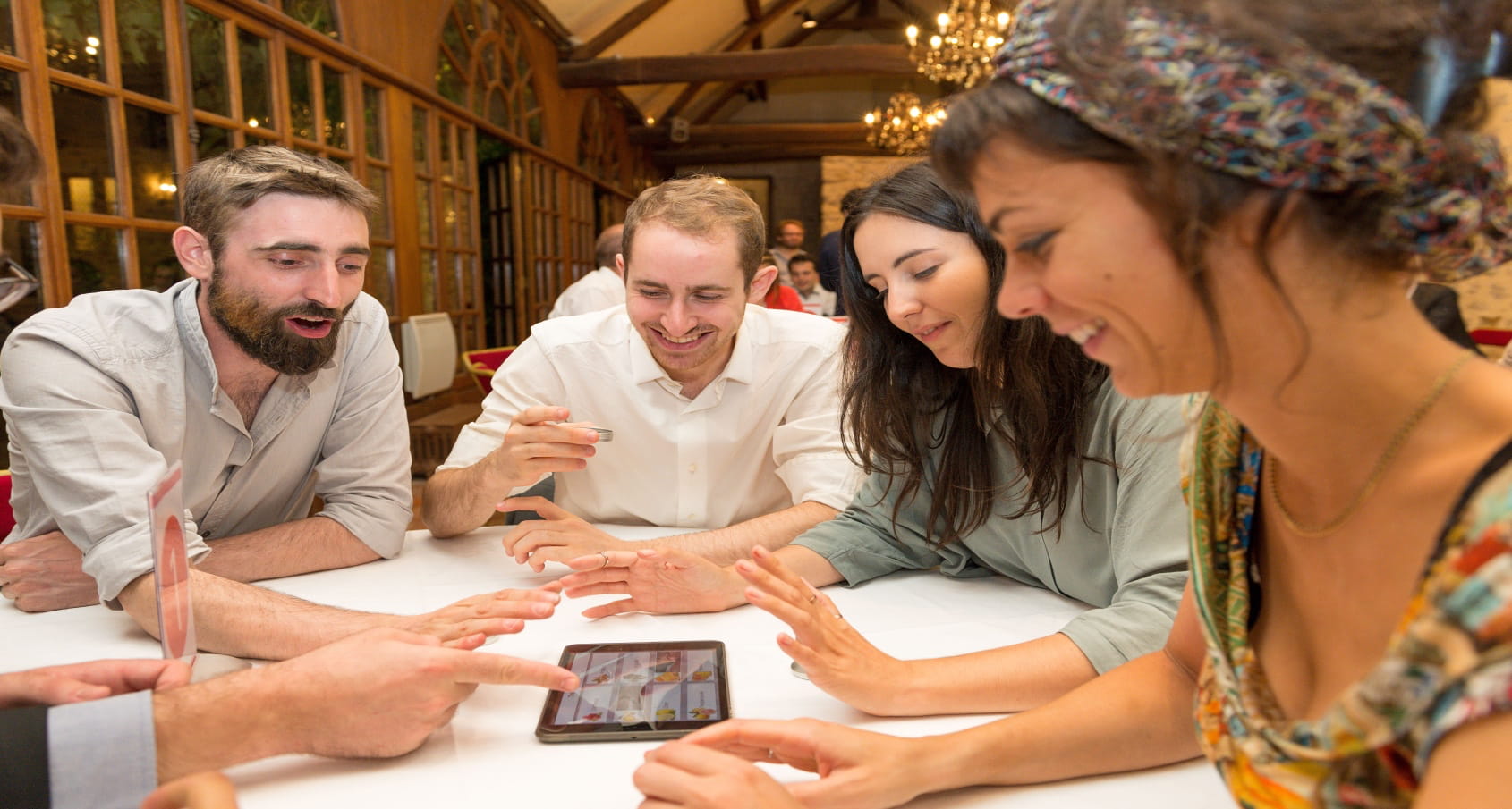 photo d'equipe composée de femmes et d'homme jouant à un quizz via une tablette tactile lors de l'animation Quizz, Blind-test et Jeux Défis, prise lors d'un séminaire d'entreprise organisée par Level Up Event agence événementielle disponible dans toute l'ile de france