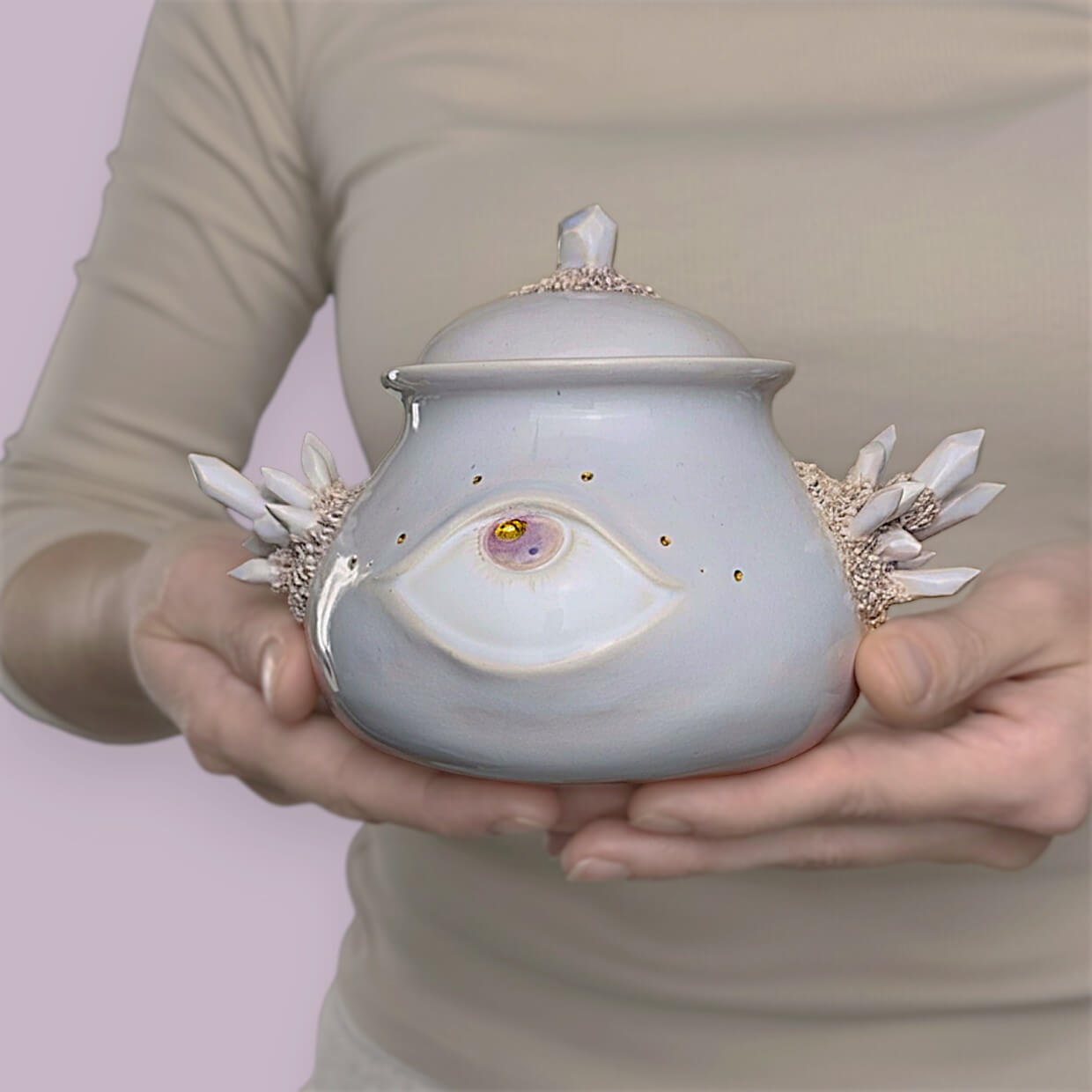 Handmade ceramic jar in soft white-lilac shade with eye detail and crystal decor, mystical style, suitable for dry goods or as a unique home accent