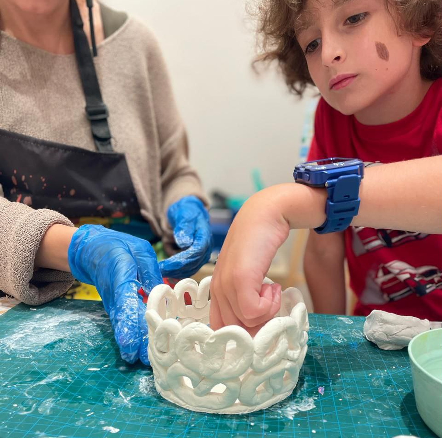 Children creating clay modeling projects age 6 to 8