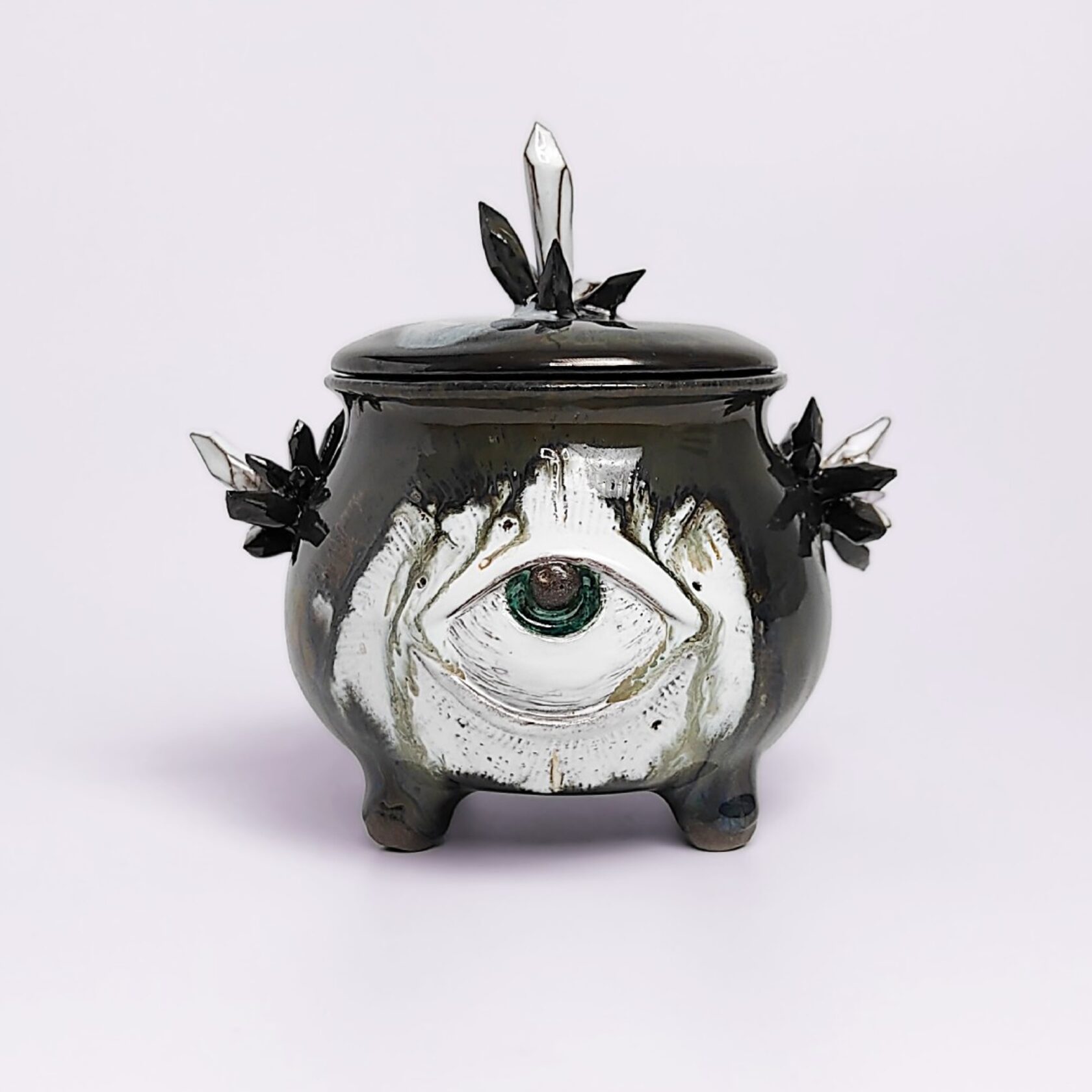 unique handmade ceramic witchy pot with a sculpted eye, black crystal accents, and a smoky dark glaze