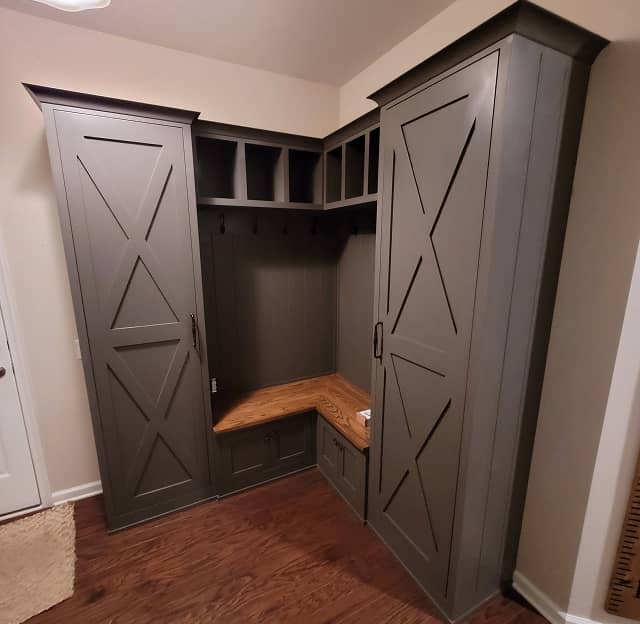 Diagonal view of farm house style mudroom cabinets with built-in bench in dark grey color