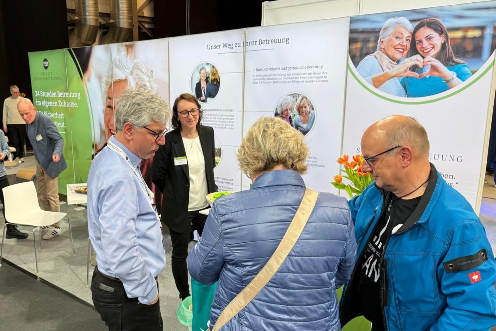 Freundliche Atmosphäre am Informationsstand mit Gästen im Gespräch