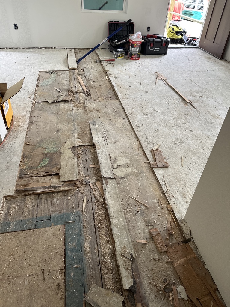 Old damaged subfloor exposed during the Austin house flip renovation