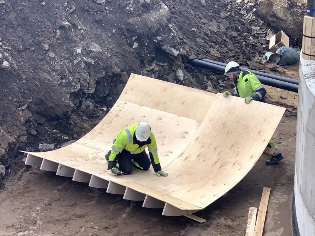 Worker fitting a bent plywood panel
