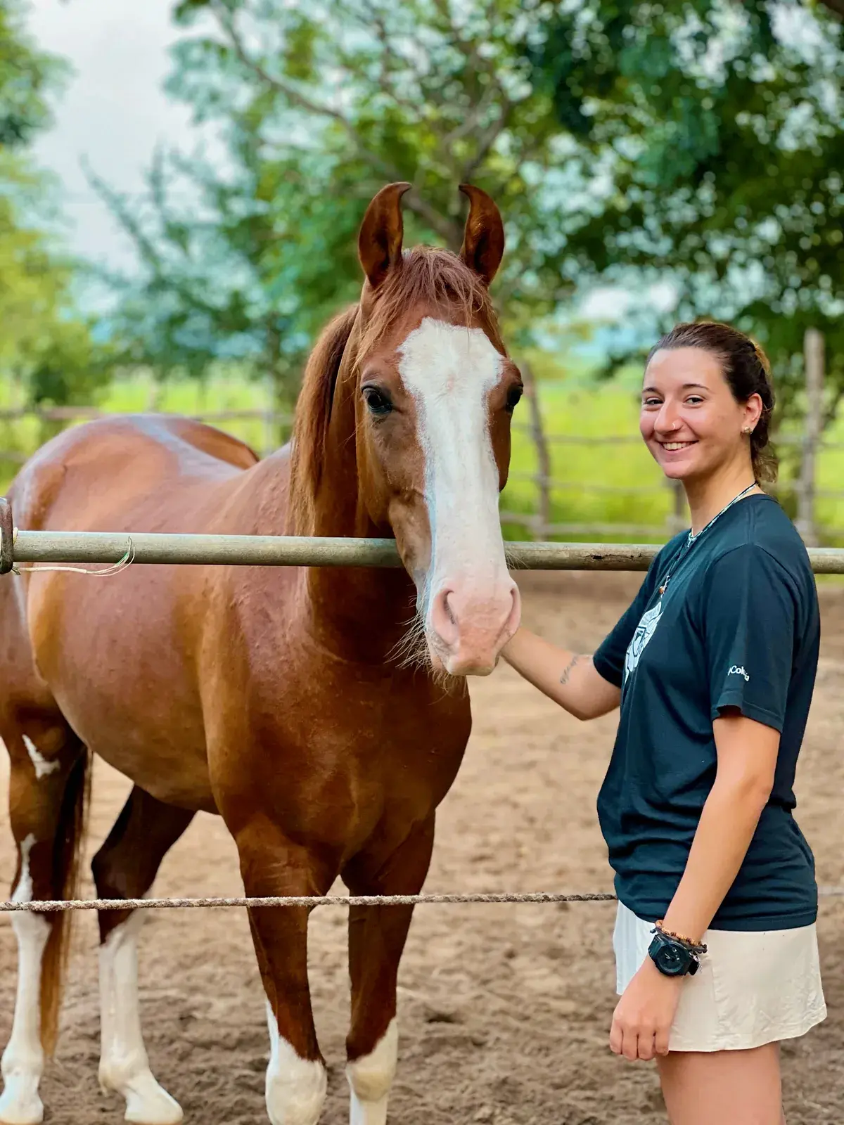 Calm chestnut horse with a white blaze standing beside a guest at Vonfidel Ranch in Sri Lanka