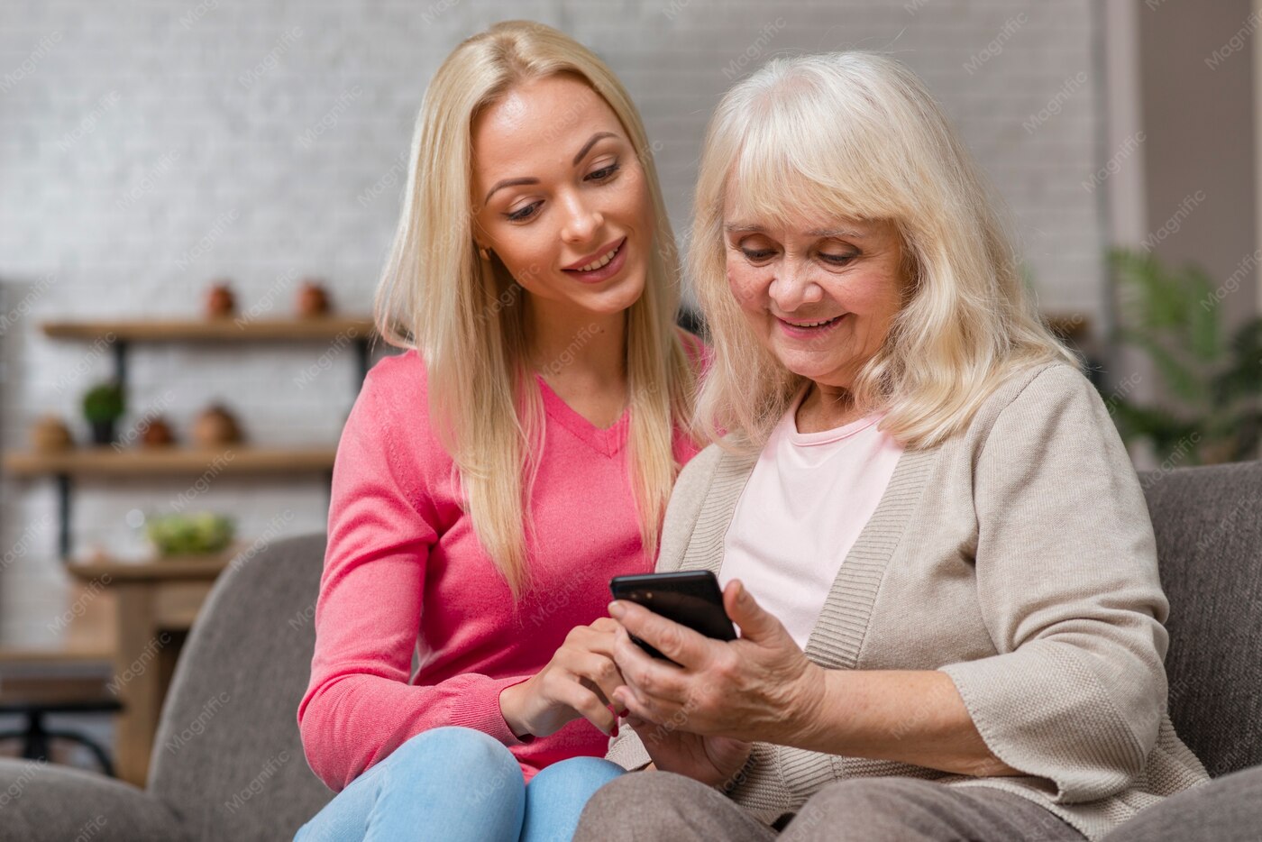 Una figlia aiuta la madre anziana con lo smartphone