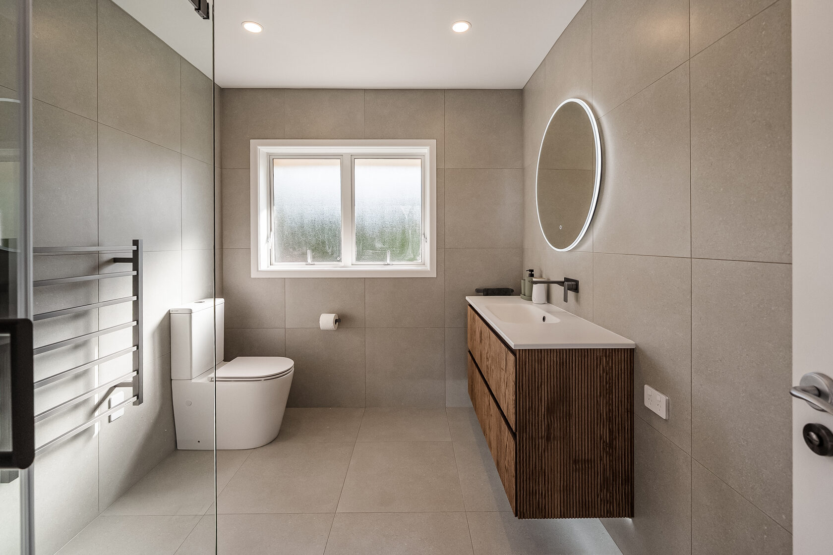 Full view of the Glenfield family bathroom with vanity, toilet and heated towel rail