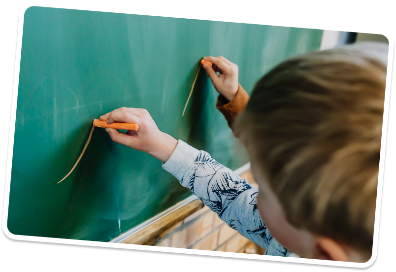 Leerling schrijft met krijt op een krijtbord