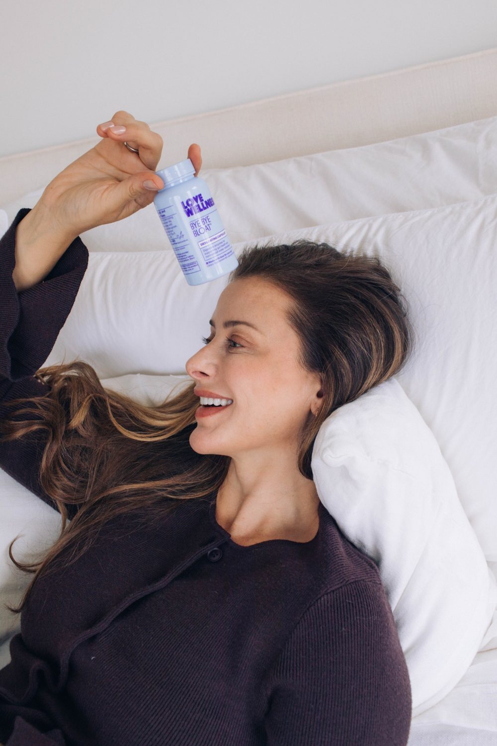 Lo in bed holding up Bye Bye Bloat