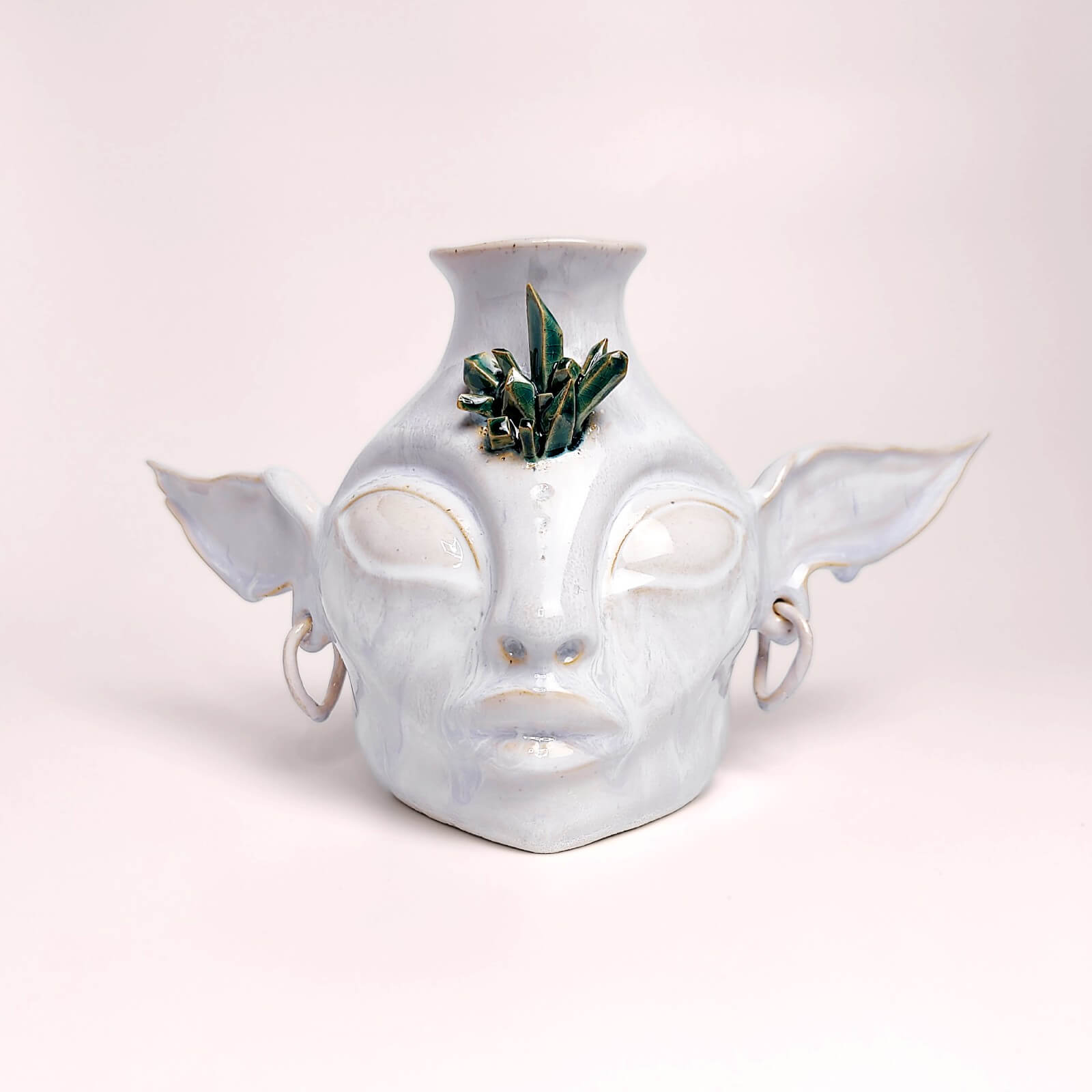 Handmade ceramic interior vase shaped like a fantasy face with elongated ears and plant decor, unique artistic home accent
