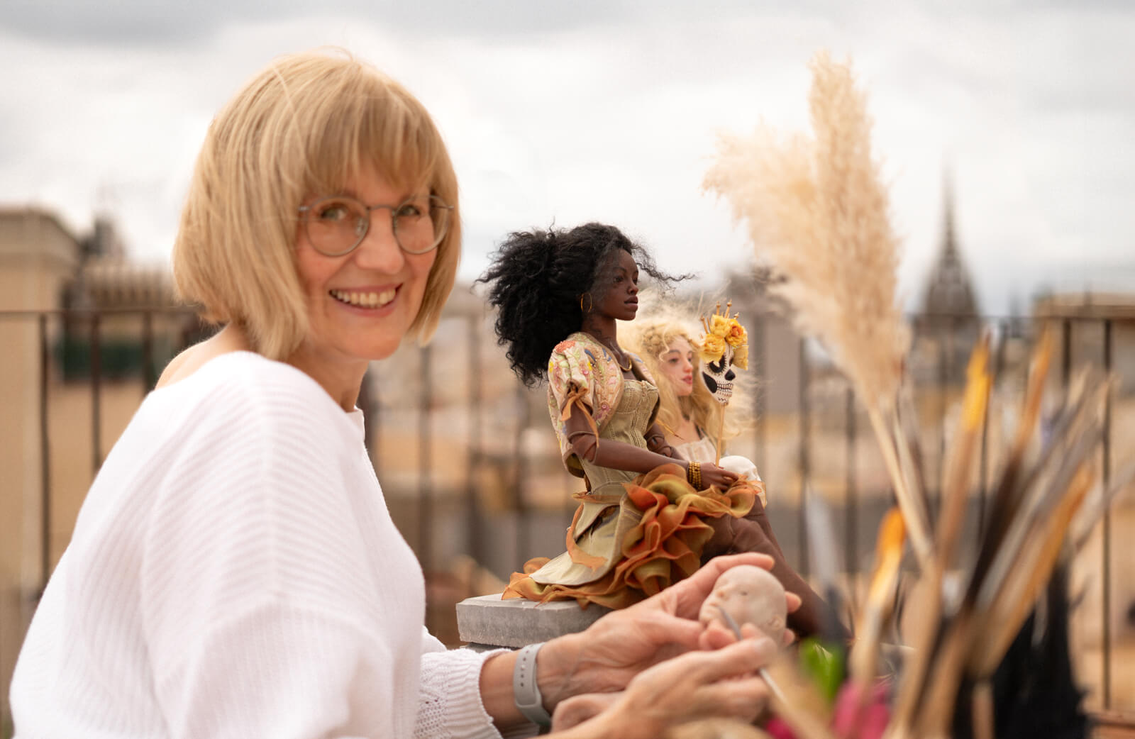 Doll artist Anna Haritonova on a rooftop in Barcelona with her handmade BJD dolls