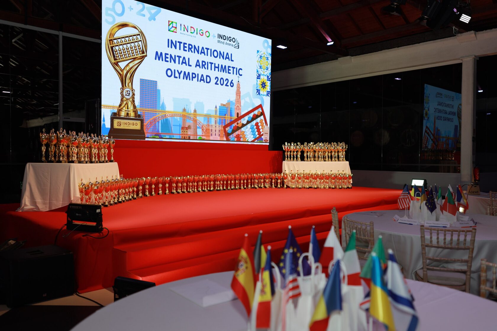 Scena International Mental Arithmetic Olympiad 2026 w Porto – setki pucharów i flaga Polski