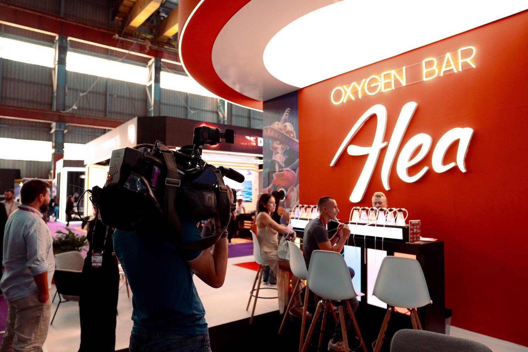 A camera operator filming at a trade show stand while the show is running
