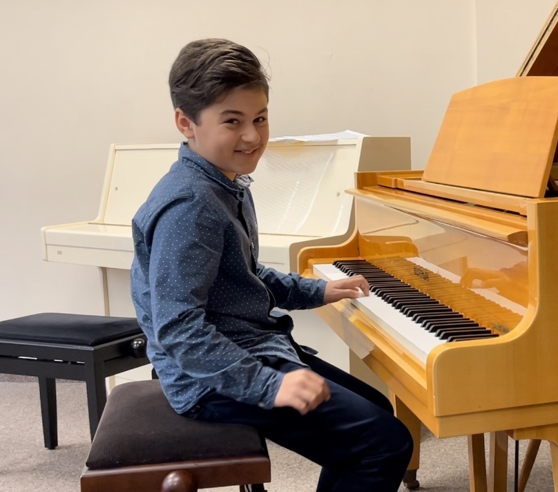 Ein Schüler des Musikateliers Aachen lächelt am Flügel