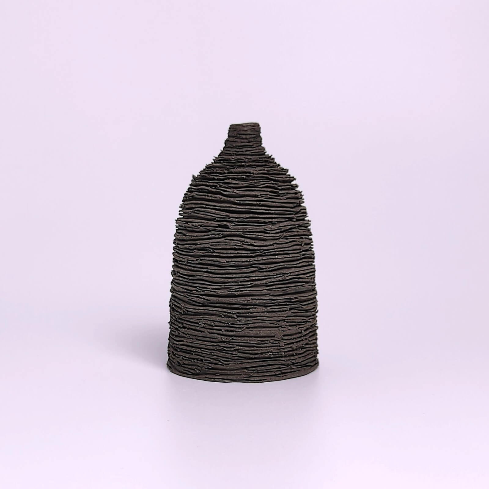 unique handmade black ceramic bud vase featuring a sculptural layered texture, minimalist modern decor for a single flower