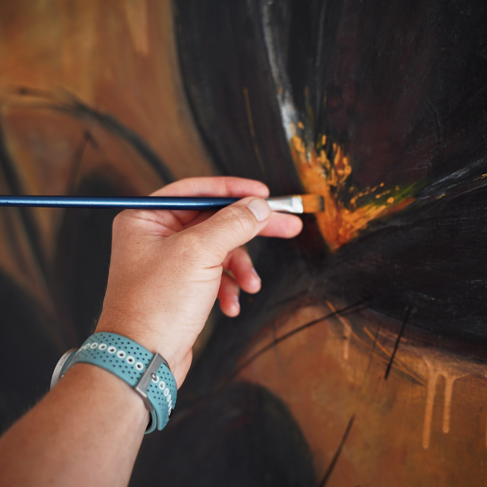The artist at work in the studio, holding a palette and brush