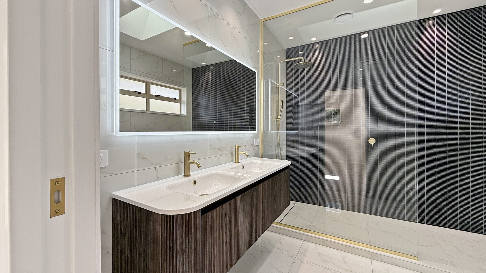 Renovated bathroom with double vanity and walk-in shower