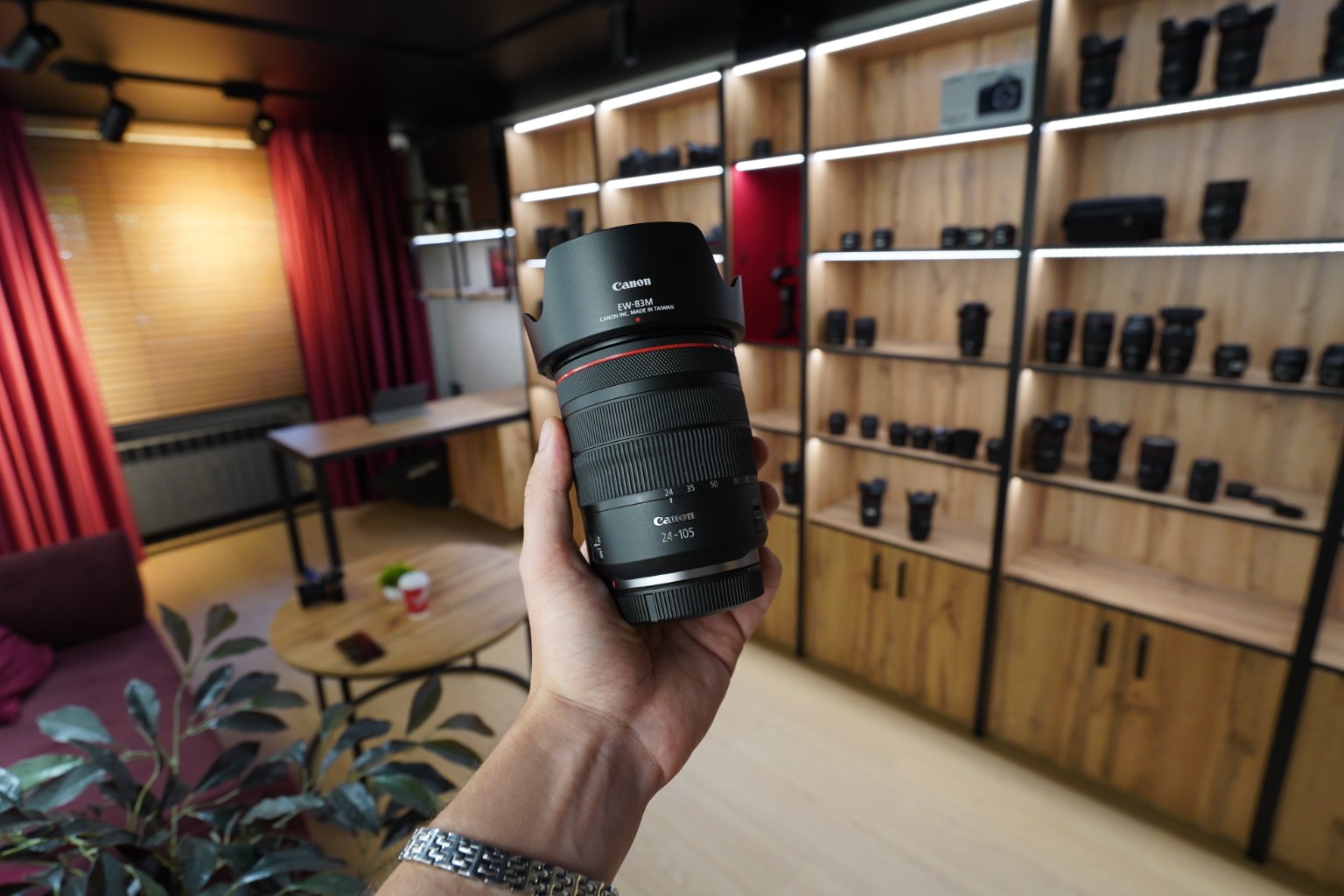 Об’єктив Canon у руках на фоні вітрин шоуруму SellYourCam