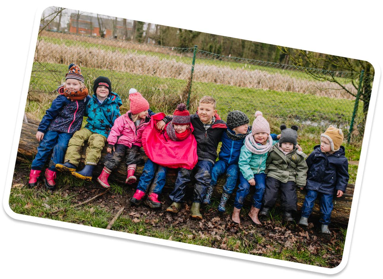 Kinderen op een rij zittend naast elkaar buiten