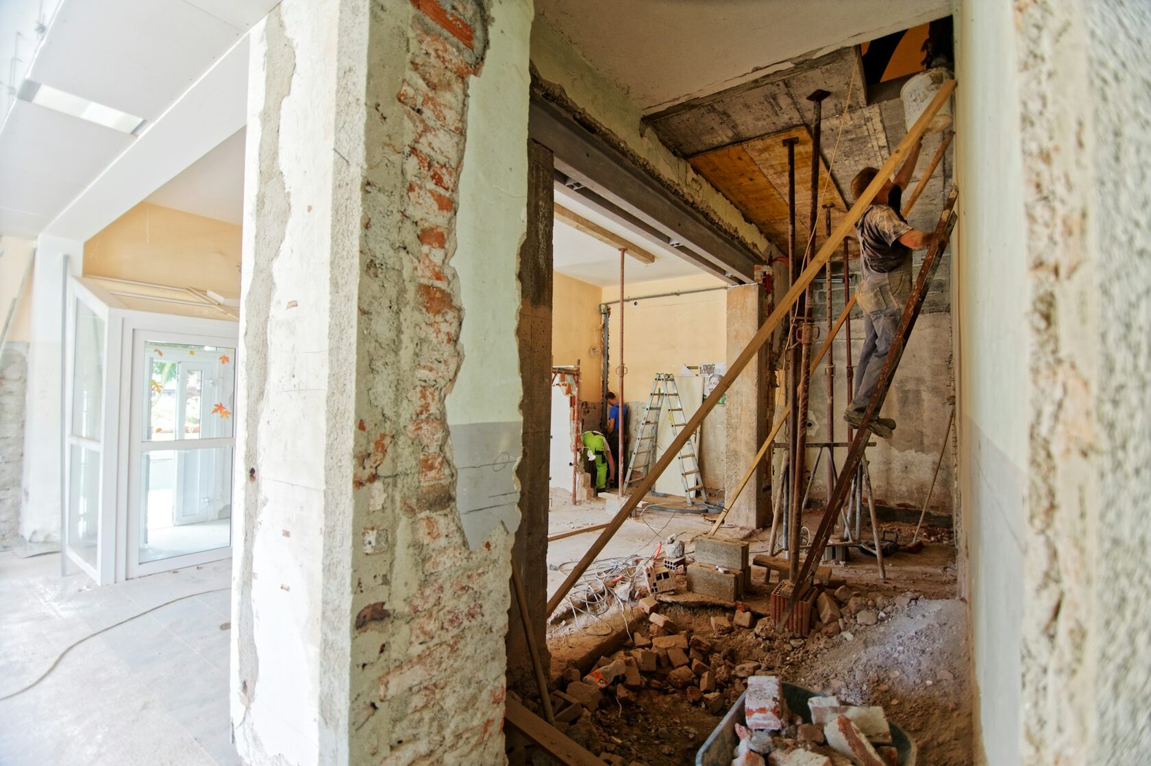 Demolition in progress, dust and exposed brick