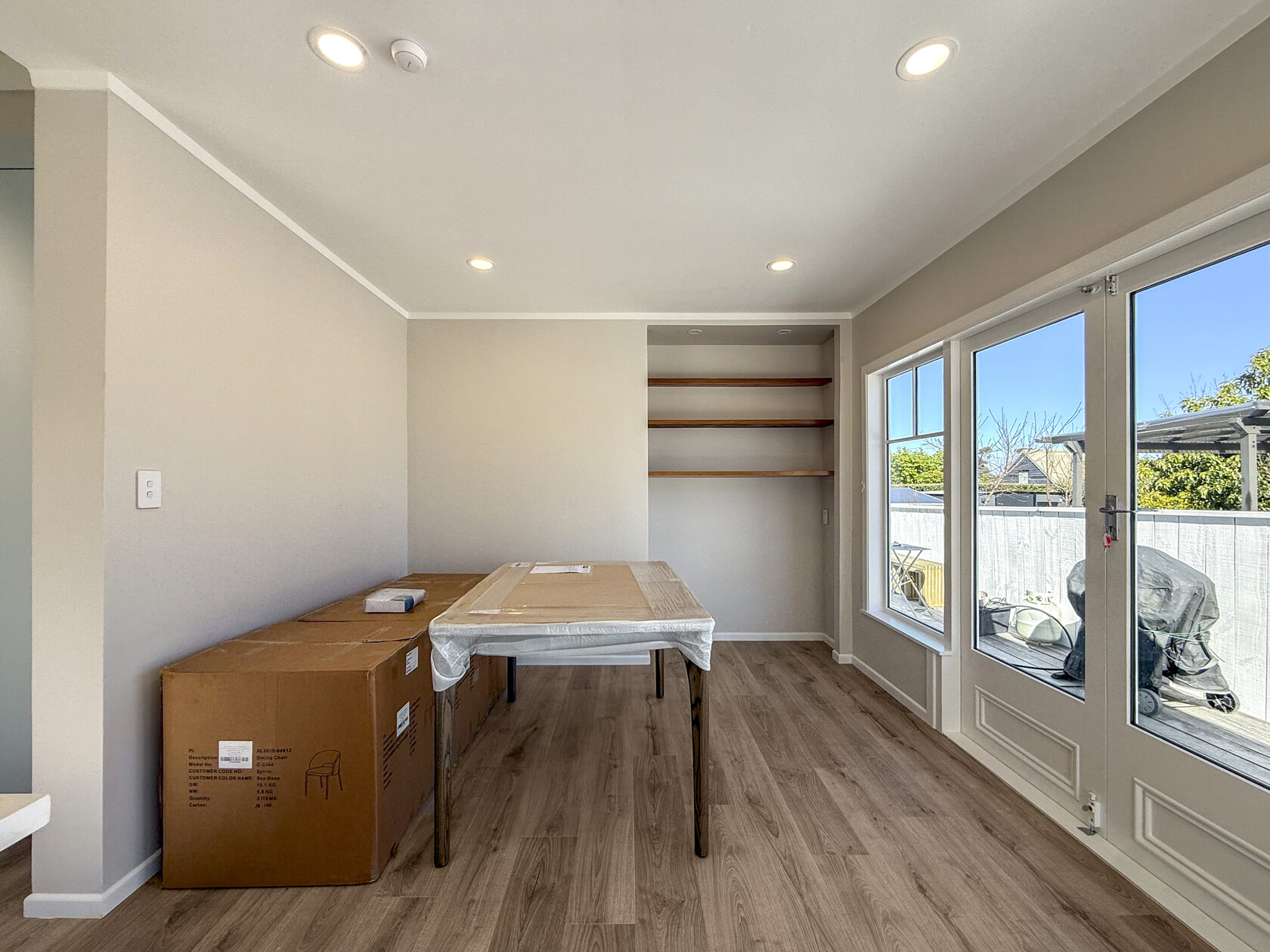 Bright dining area with timber-look floor and glazed doors to the outside