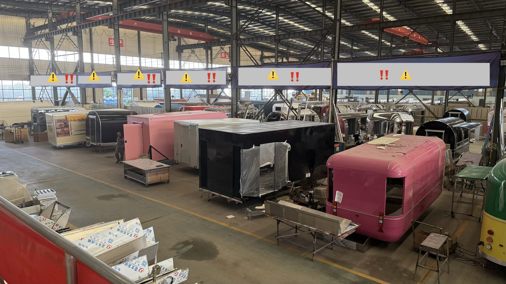 Food trailer production floor in China with the manufacturer's banners overhead — factory visit, May 2026
