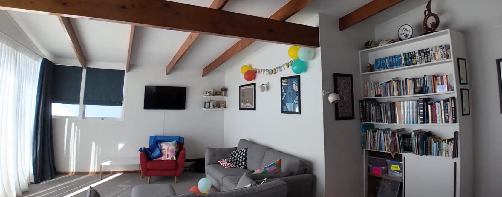Before: Hillcrest living room corner with television, sofa, shelving and exposed timber beams