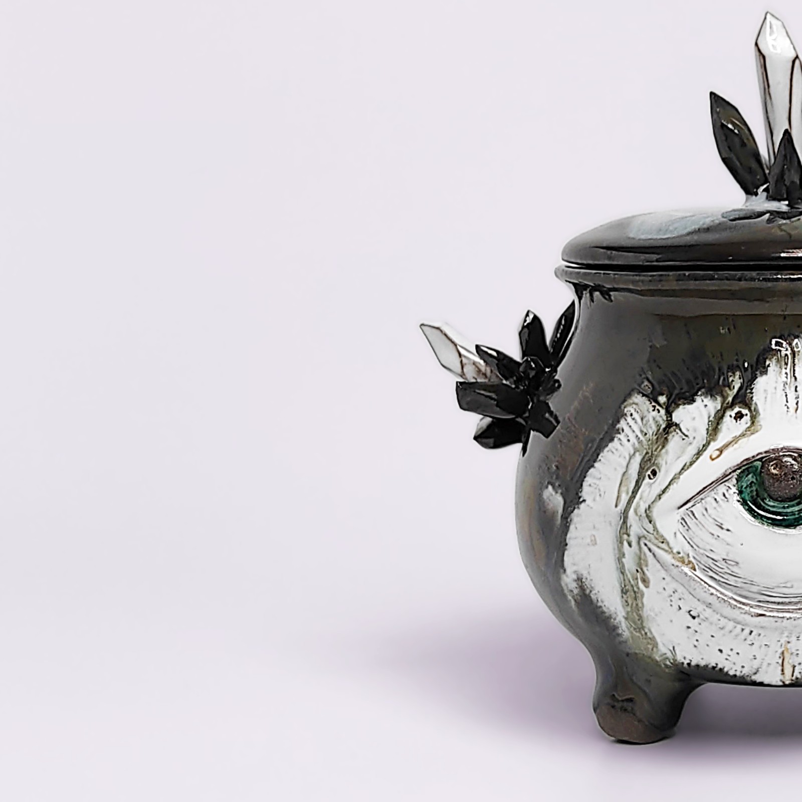 unique handmade ceramic witchy pot with a sculpted eye, black crystal accents, and a smoky dark glaze