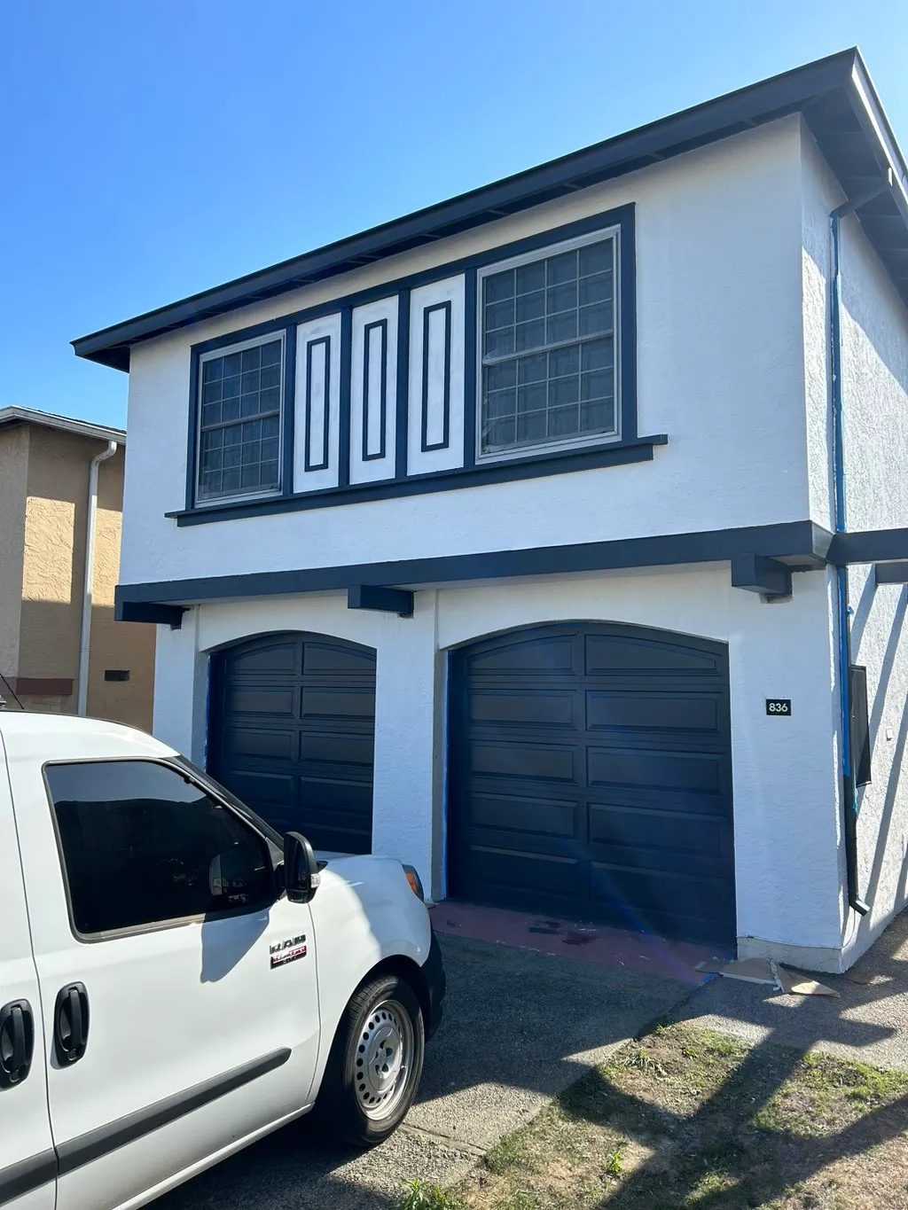 Exterior house painting, white stucco with navy trim and garage doors, North Miami FL