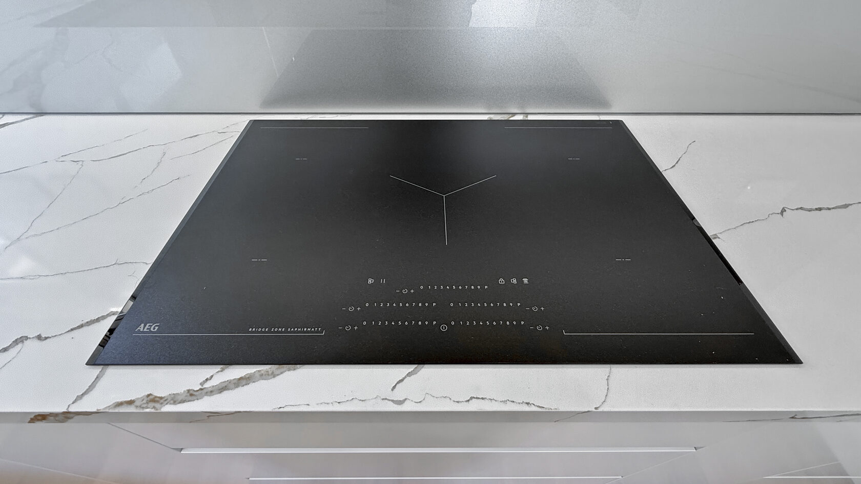 Close view of the induction cooktop set into a stone benchtop in St Heliers.