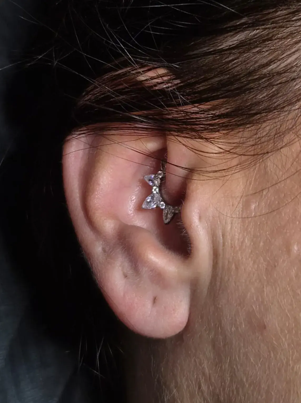 Piercing d'oreille avec bijou fleur en strass, réalisé chez Ino-Ink à Gometz-la-Ville