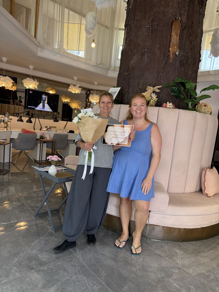 Graduate with her certificate and bouquet, with Nina