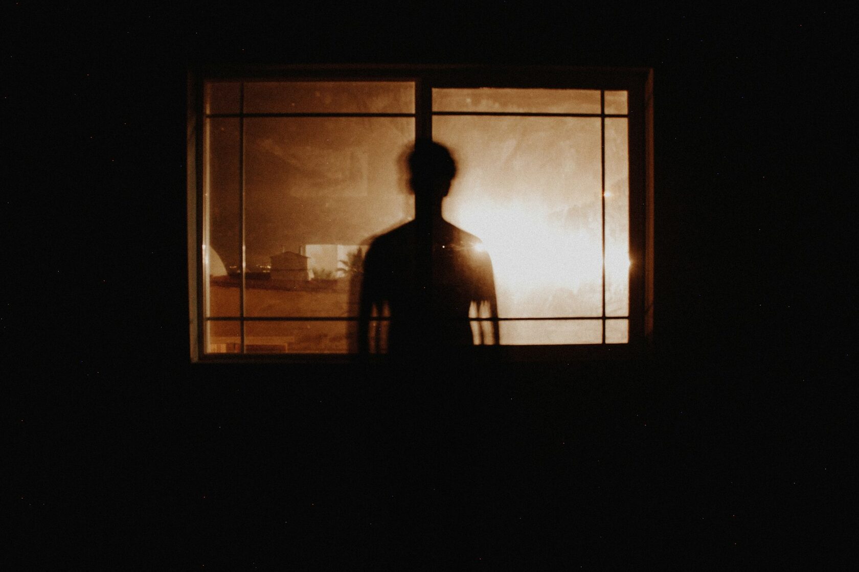 A man's back by a window