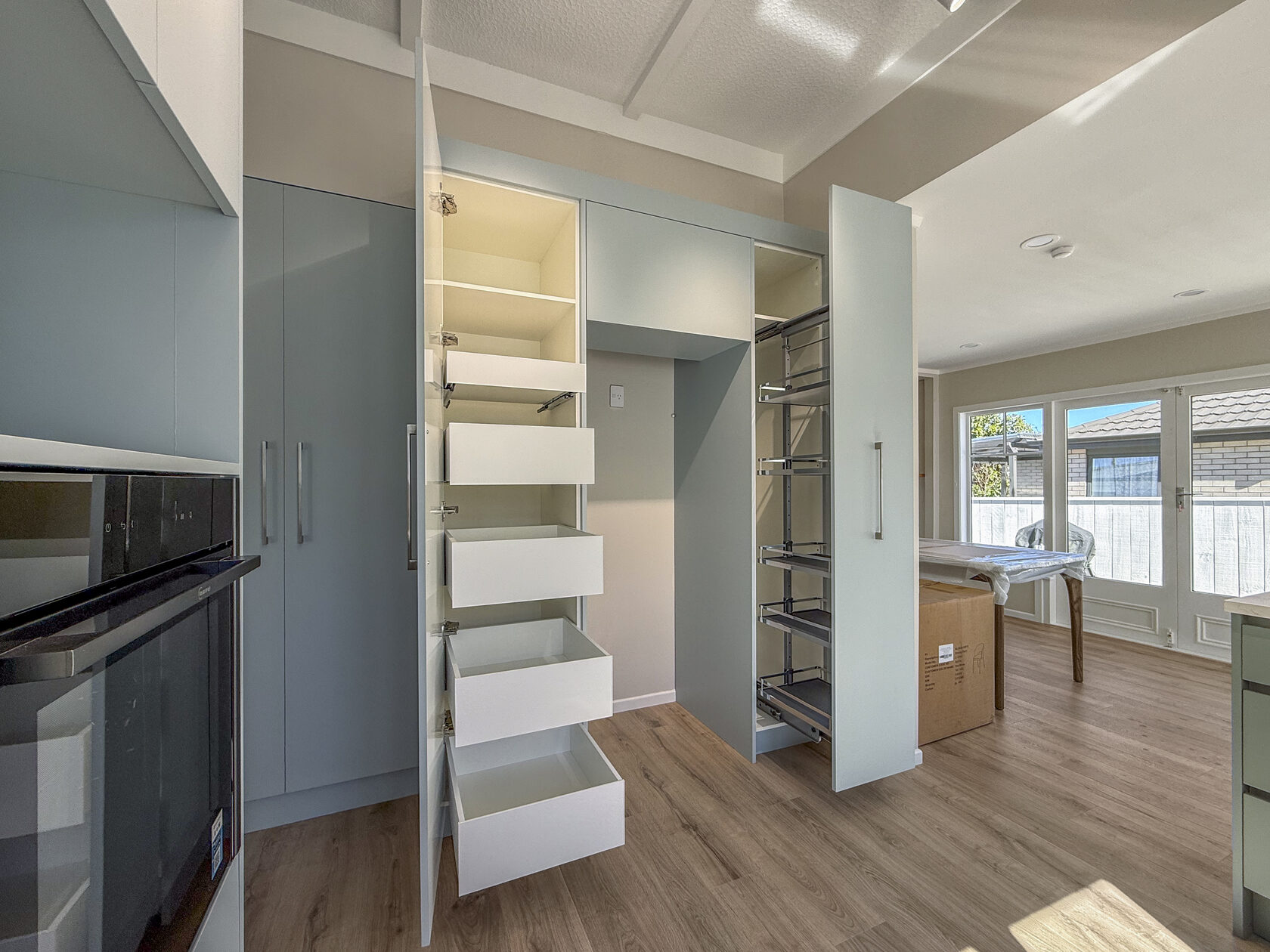 Open kitchen cabinet showing pull-out drawers and internal shelving