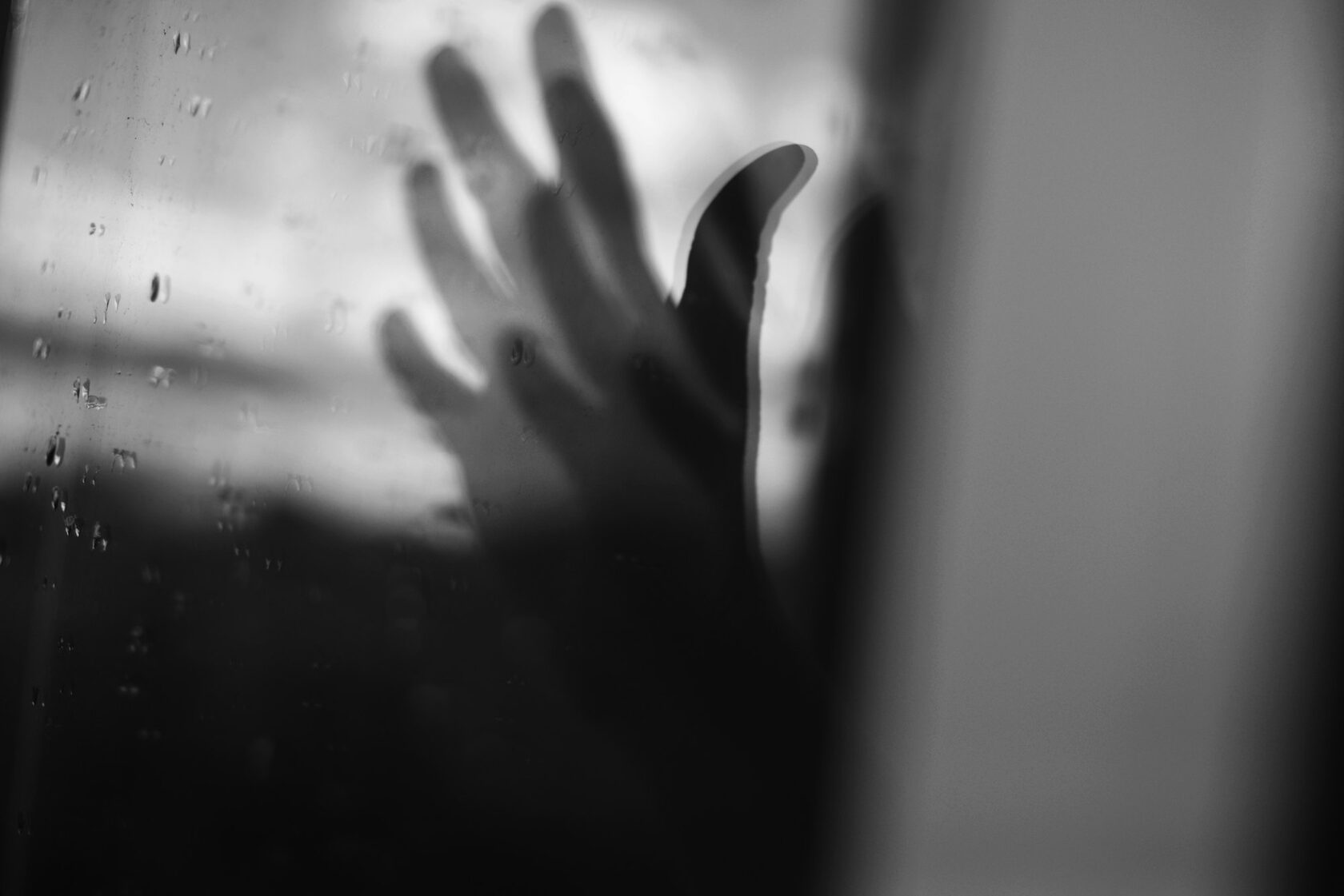 A hand pressed against a window