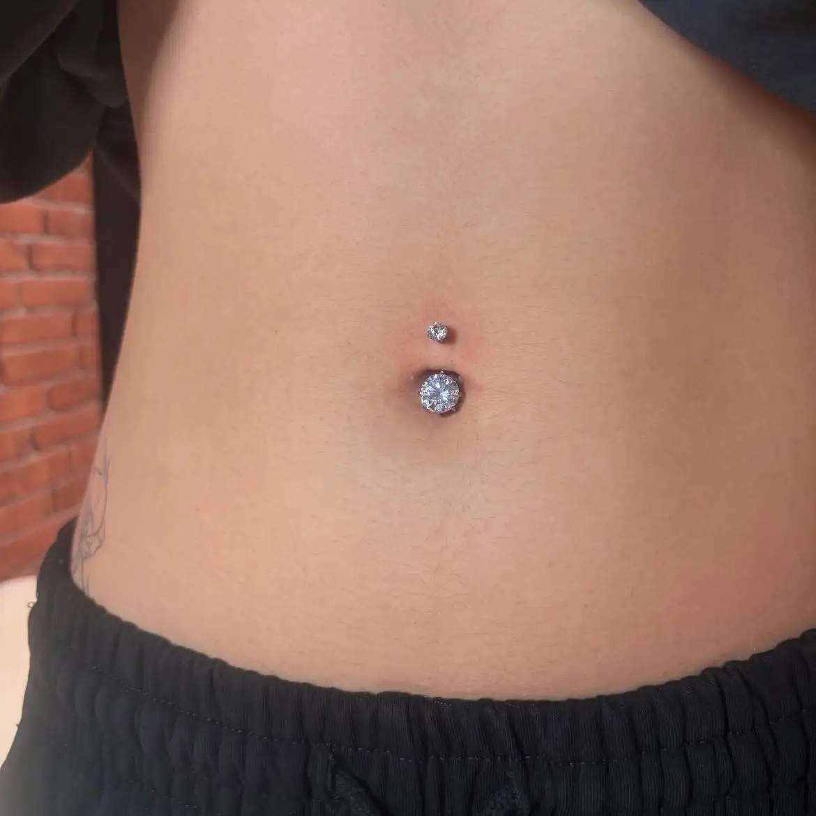 Piercing nombril avec bijou strass, réalisé par Camille chez Ino-Ink