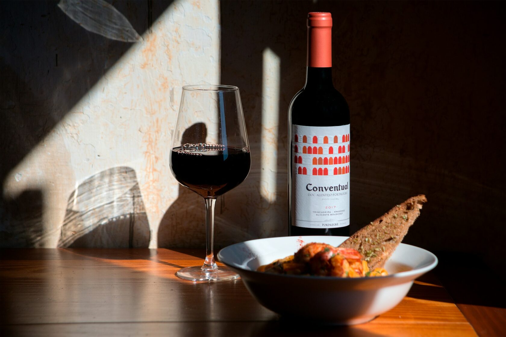 A glass of deep ruby Alentejo red wine catching the warm late-afternoon sun