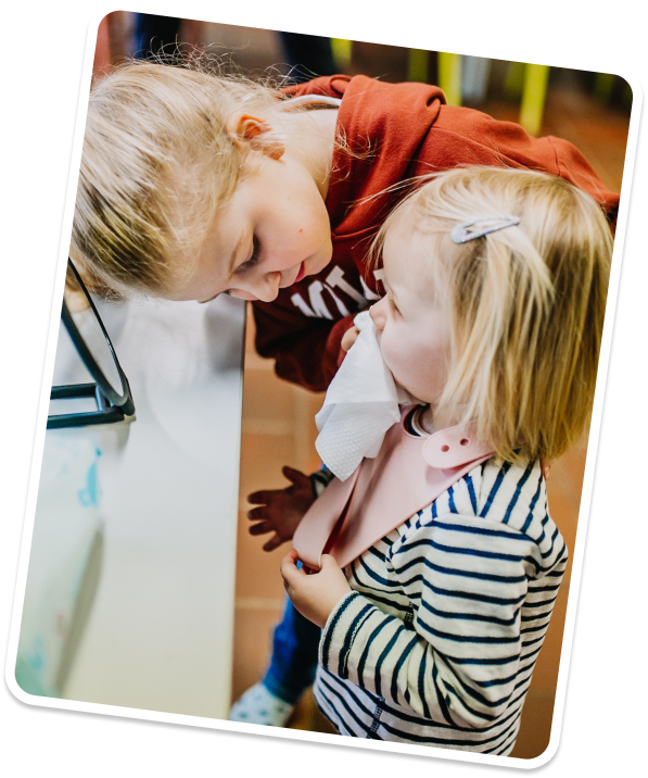 Meisje helpt een kleuter