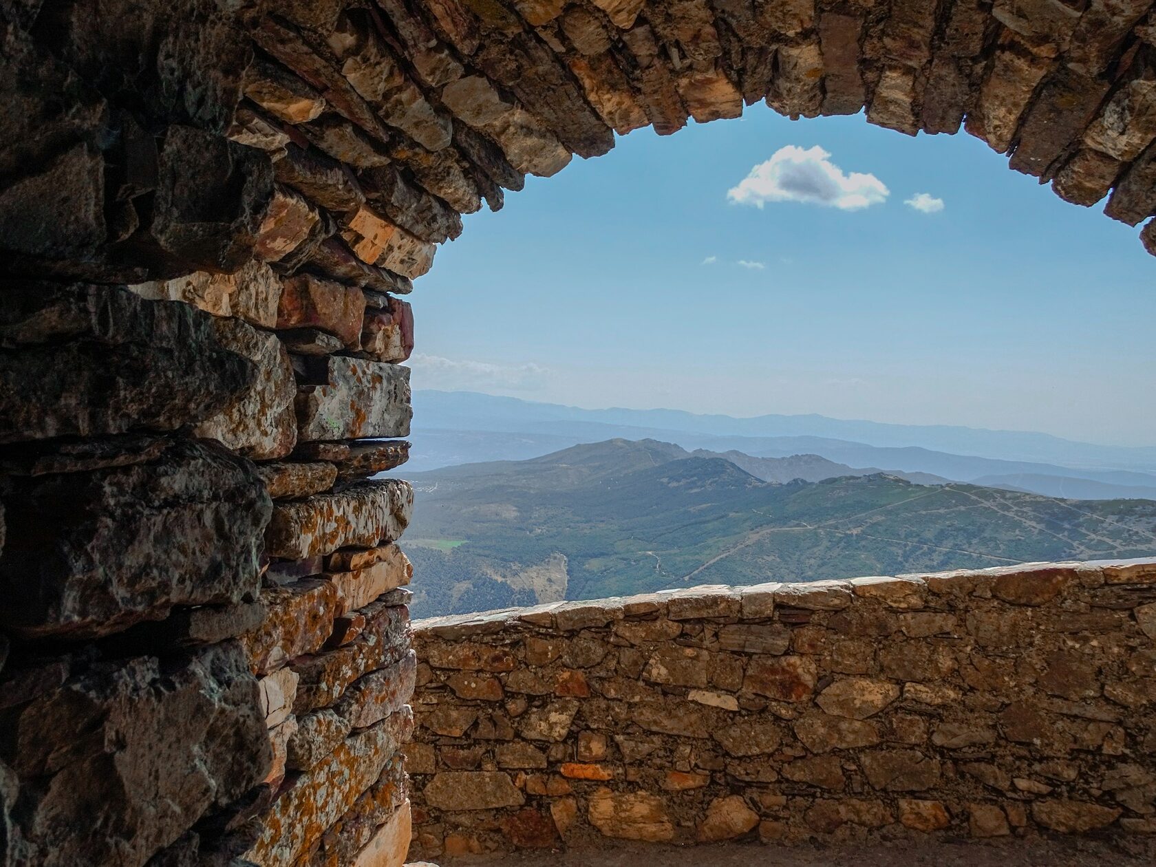 Stone arch terrace overlooking a Mediterranean landscape at golden hour