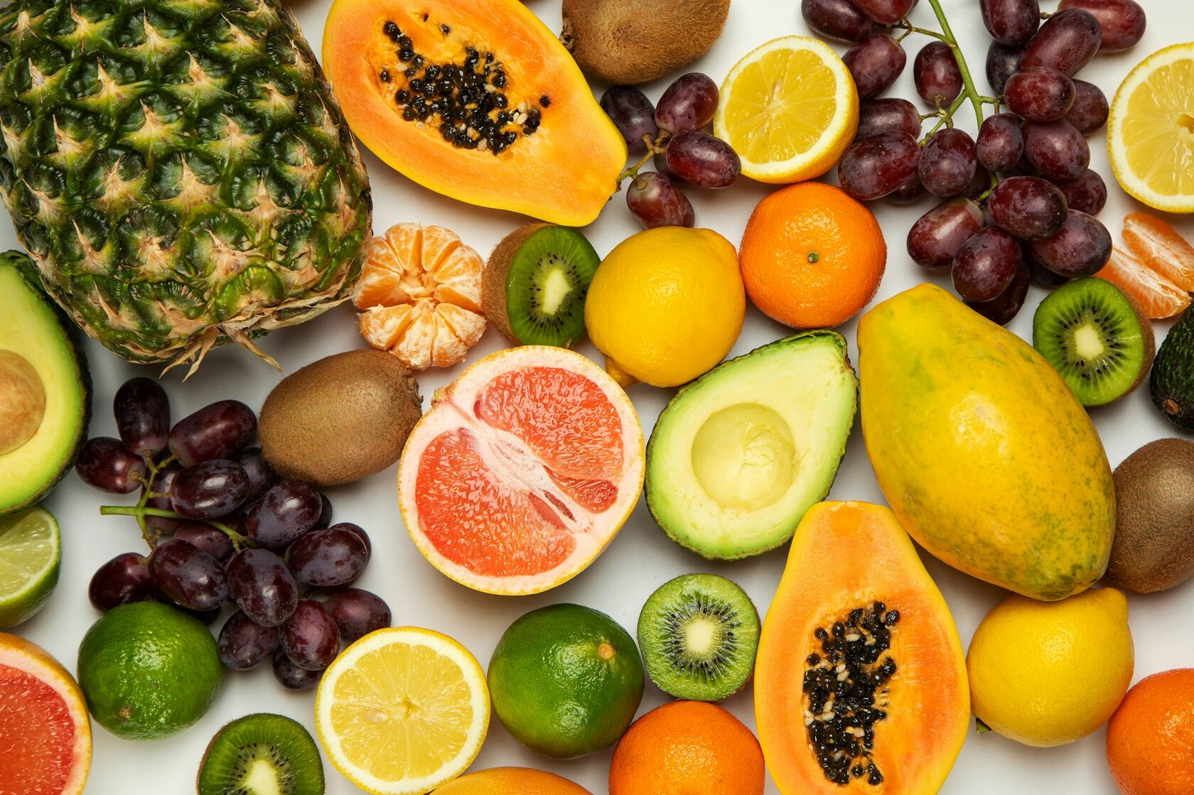 A vibrant flat-lay of tropical fruits — mango, papaya, pineapple, watermelon — typical of a Fruit Party Deluxe 2 weekly box.