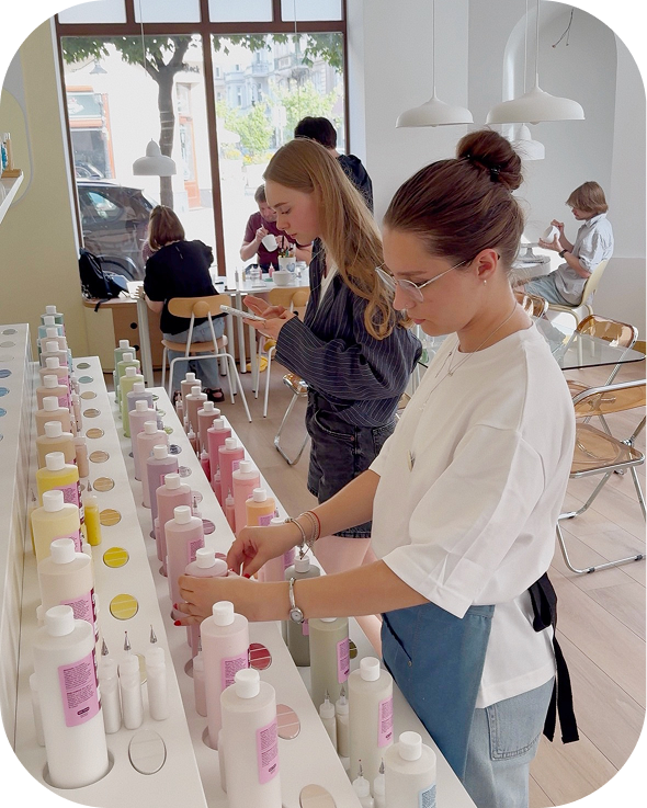 The paint bar at Create Cafe Poznań — a guest choosing colours for painting ceramics
