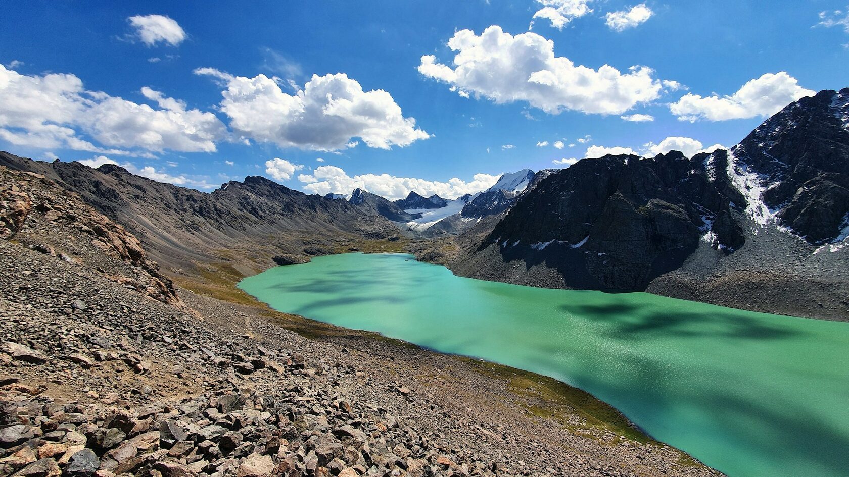 Turquoise Ala-Kul Lake below glaciers and dramatic peaks of the Terskey Ala-Too range