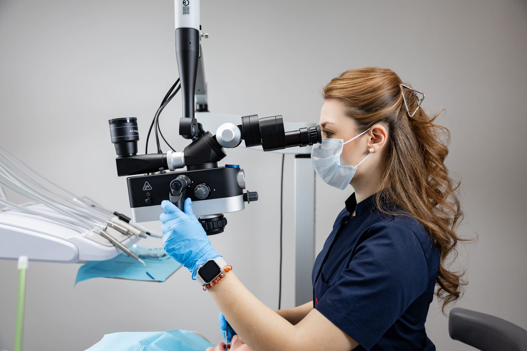 Врач My Dental Clinic лечит зуб под дентальным микроскопом