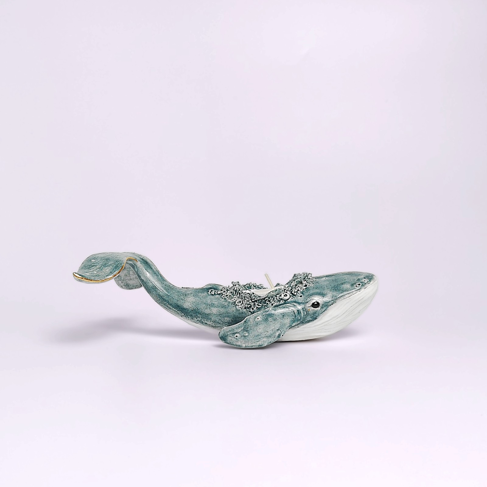 Unique handmade lagoon-colored ceramic whale with detailed sculptural texture and a built-in candle, inspired by ocean forms