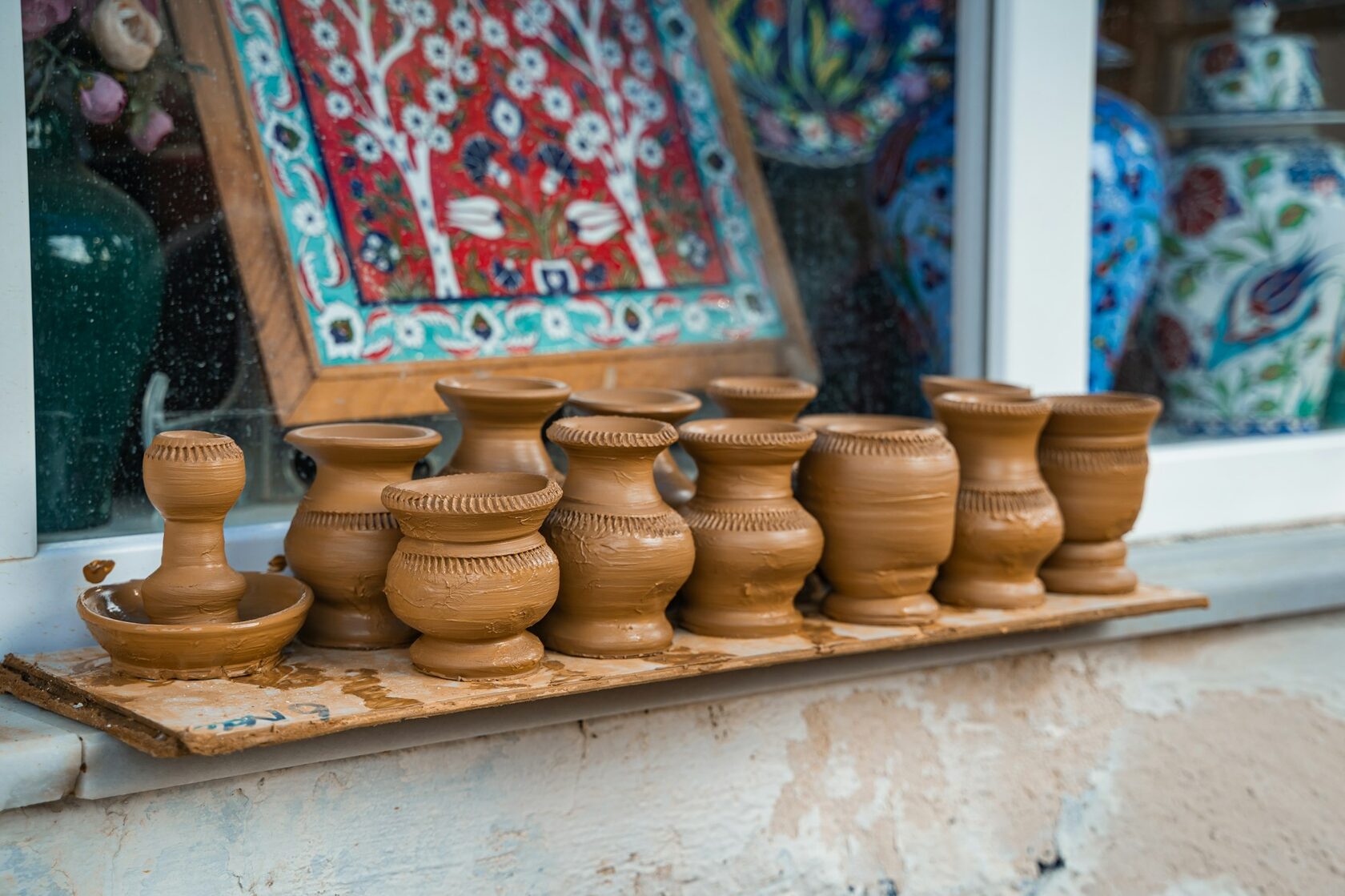 Coleção de jarras de terracota sobre prateleira de madeira